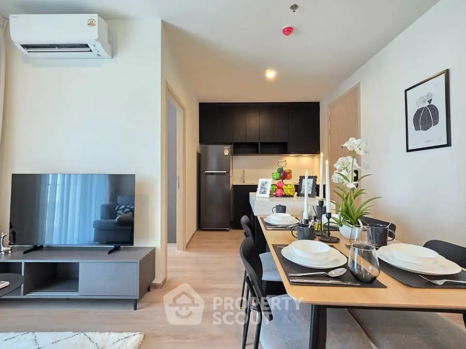 Modern open-plan living room and kitchen with stylish dining area in a contemporary apartment.