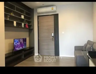 Modern living room with sleek design, featuring a wall-mounted TV and stylish shelving.