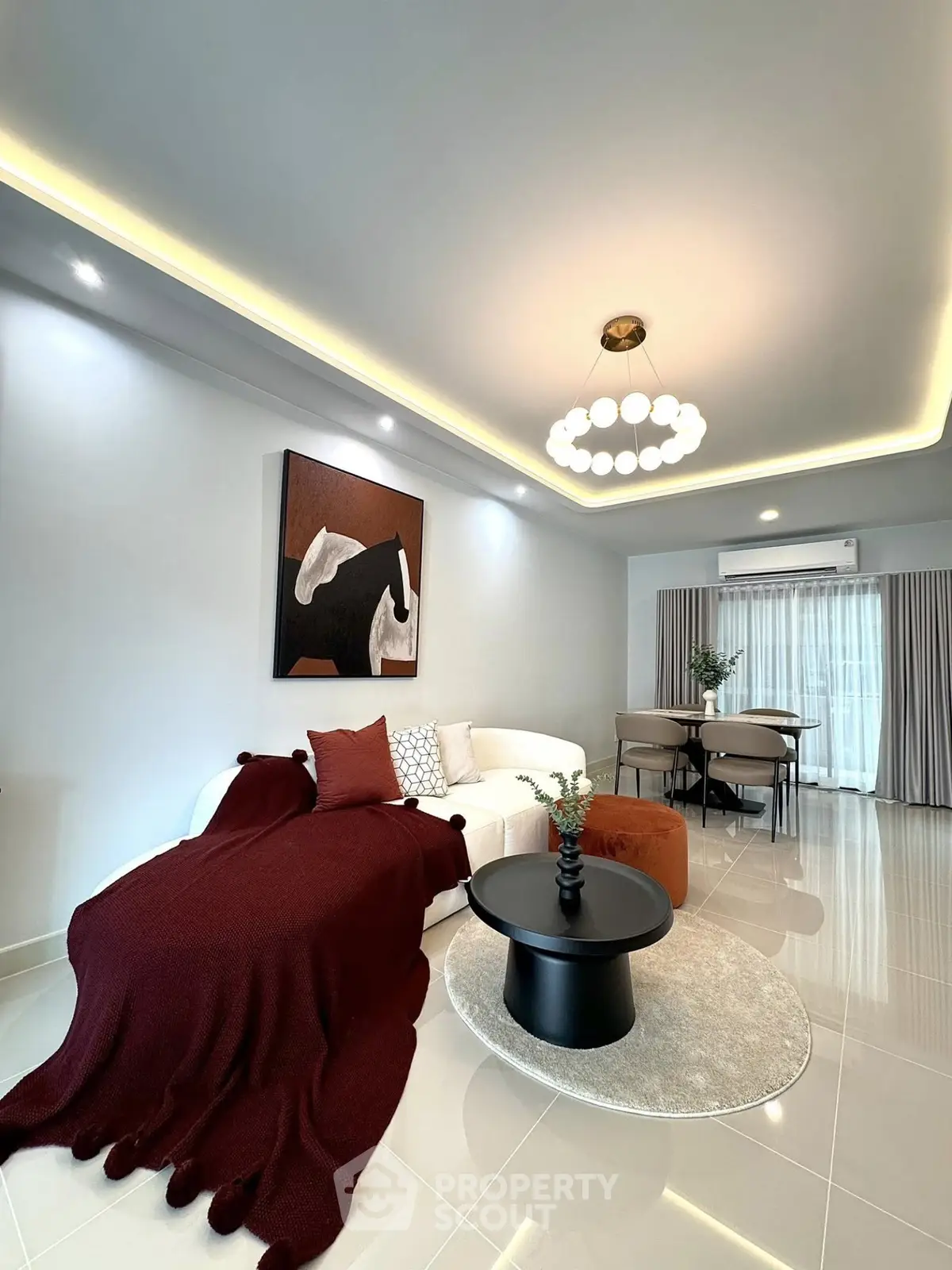 Modern living room with elegant decor, featuring a cozy sofa, stylish lighting, and contemporary artwork.