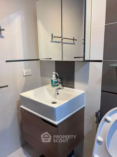 Modern bathroom with sleek sink and mirrored cabinet in stylish apartment.