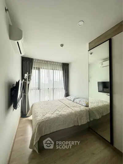 Modern bedroom with large mirror and natural light in stylish apartment