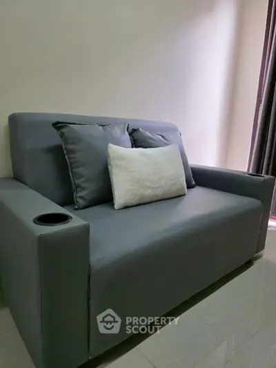 Modern gray sofa with plush cushions in a cozy living room setting.