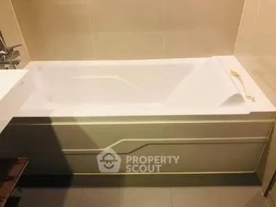 Modern bathroom with sleek bathtub and neutral tile design