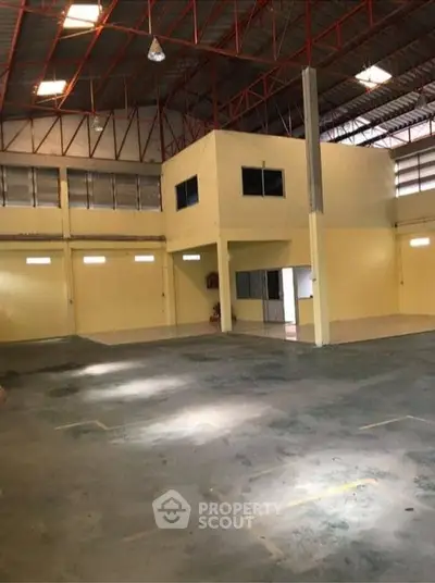 Spacious industrial warehouse with high ceilings and ample natural light.