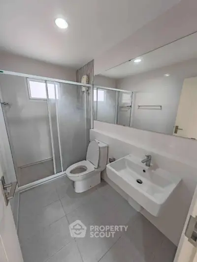 Modern bathroom with sleek fixtures and spacious shower area.