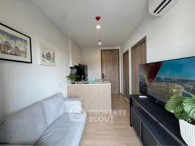 Modern living room with sleek furniture and wall art, featuring a cozy sofa and flat-screen TV.