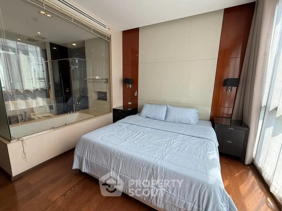 Luxurious bedroom with modern design and glass-walled ensuite bathroom in high-end apartment.