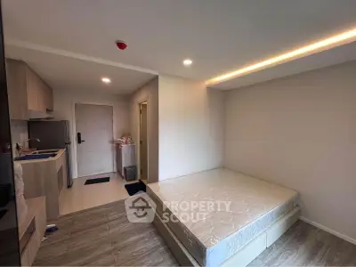 Modern studio apartment with compact kitchen and cozy sleeping area, perfect for urban living.