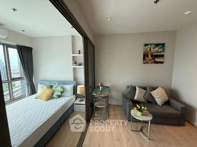 Modern studio apartment with cozy living area and city view, featuring stylish decor and natural light.