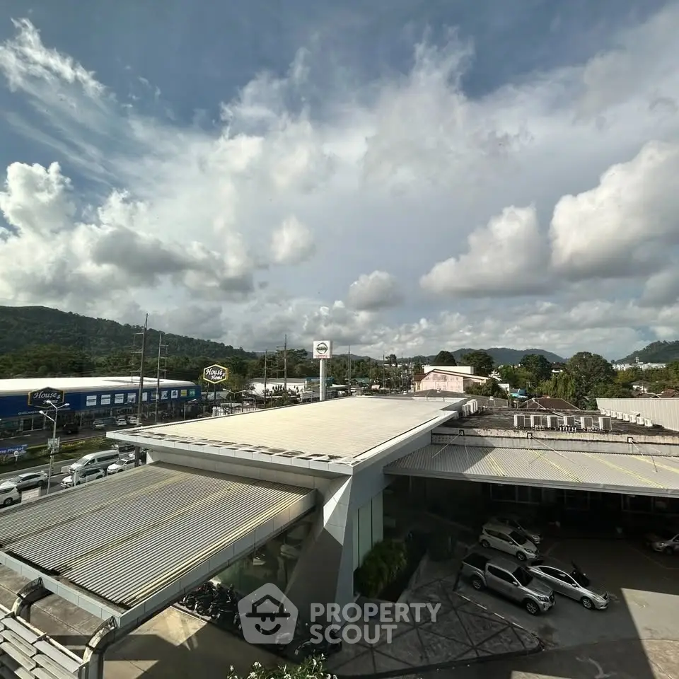 Expansive commercial building with modern design and ample parking space under a vibrant sky.