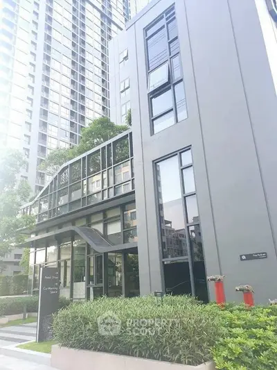 Modern high-rise building exterior with sleek design and lush greenery.