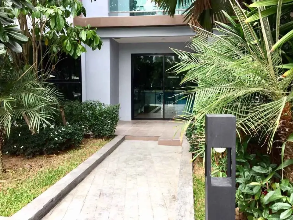 Modern building entrance with lush greenery and sleek design