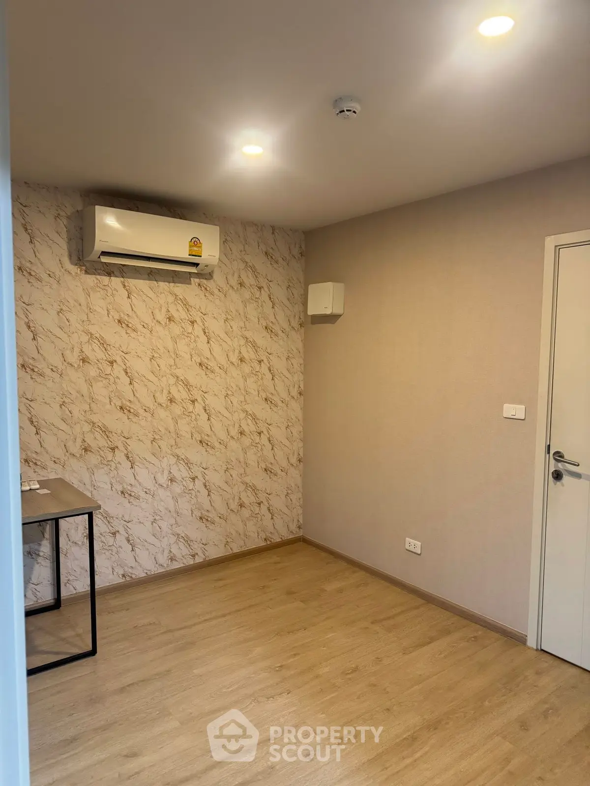 Modern empty room with air conditioning and stylish wallpaper, perfect for a home office or study.