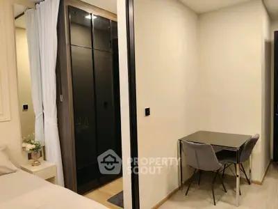 Modern bedroom with sleek black wardrobe and cozy study area