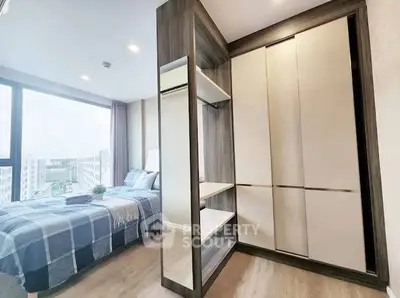 Modern bedroom with large window and stylish wardrobe in a high-rise apartment.