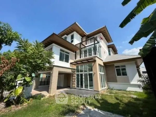Stunning modern multi-story house with large windows and lush greenery, perfect for family living.