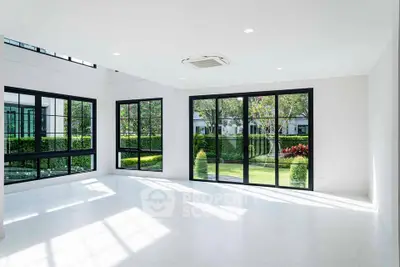 Spacious modern living room with large windows and garden view, perfect for natural light lovers.