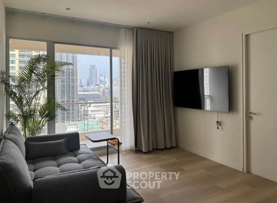 Modern living room with city view, featuring a sleek sofa and wall-mounted TV, perfect for urban living.