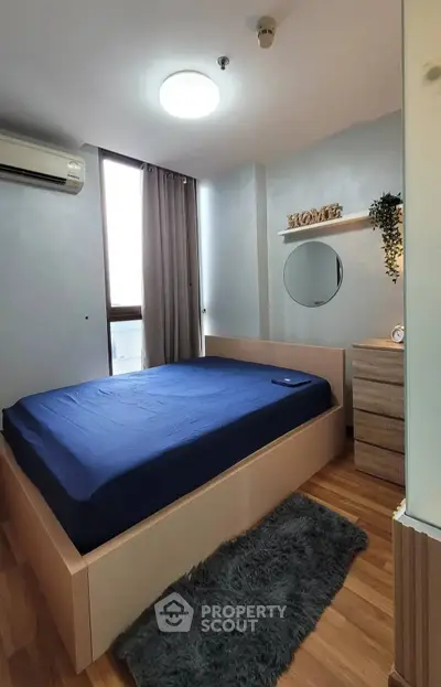 Cozy bedroom with modern decor and natural light, featuring a plush bed and stylish furnishings.