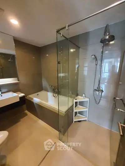 Modern bathroom with glass shower and bathtub in luxury apartment