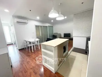 Modern open-plan living room with stylish dining area and contemporary lighting.