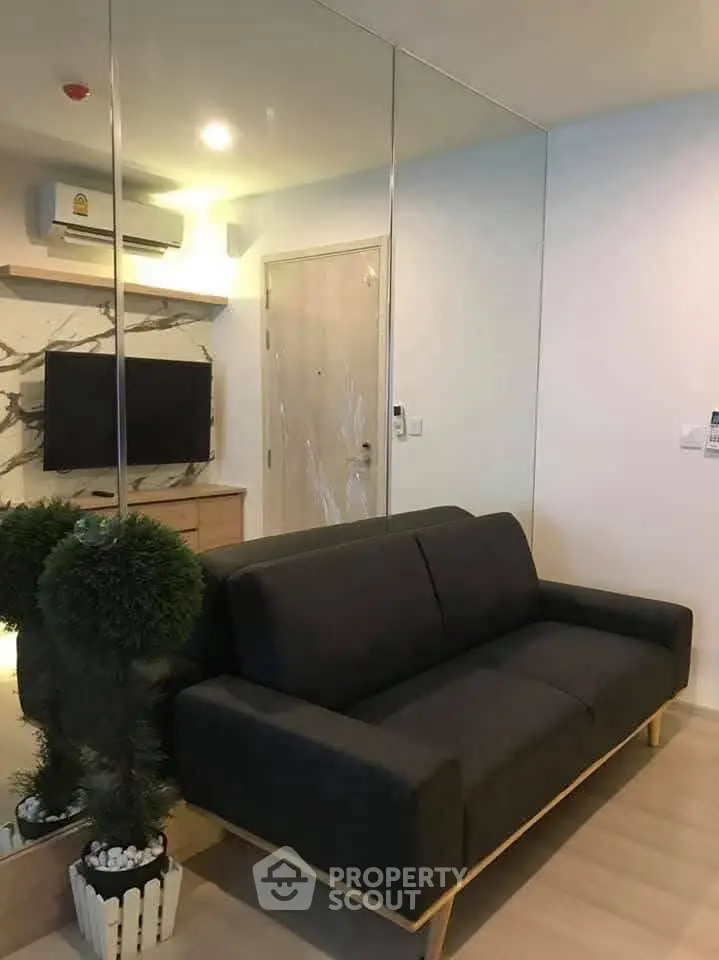 Modern living room with sleek black sofa and mirrored wall design