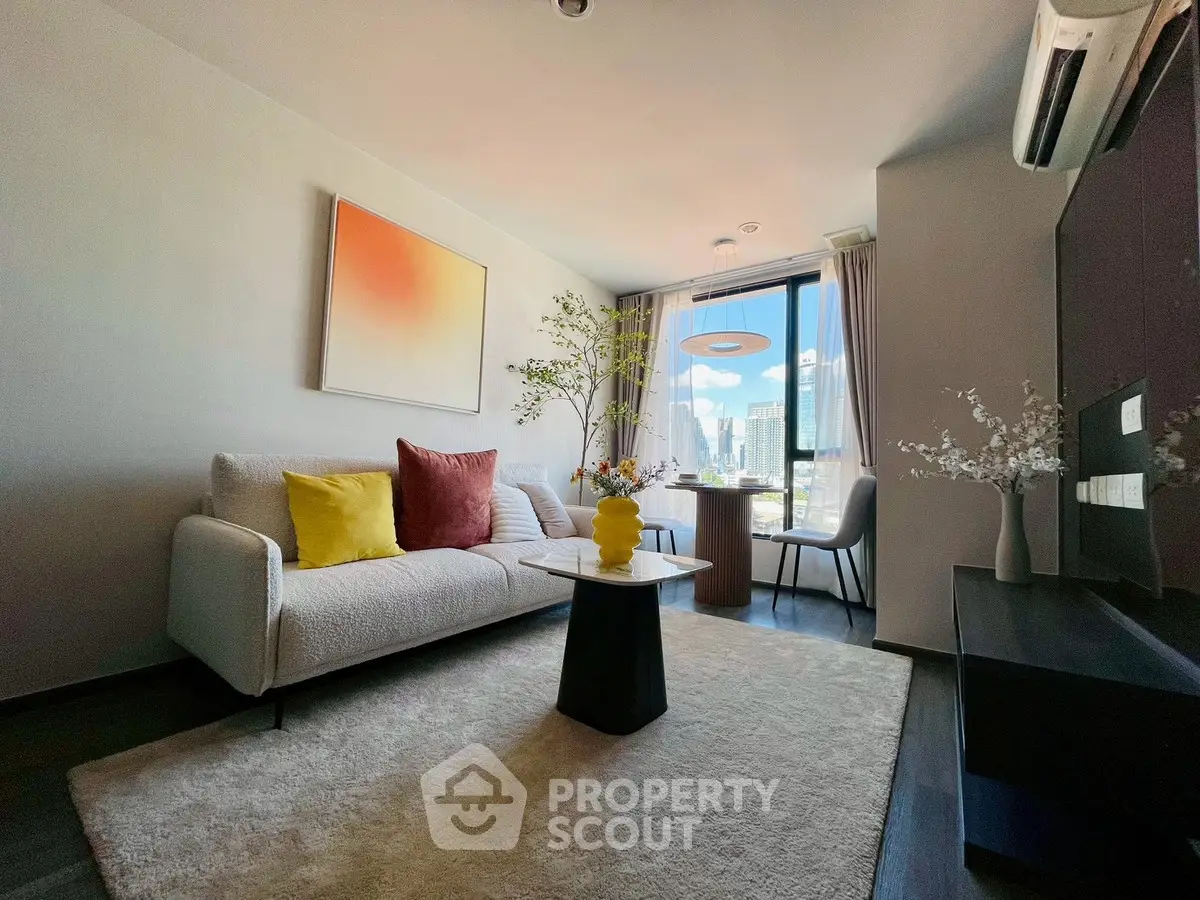 Modern living room with city view, stylish decor, and cozy seating area.