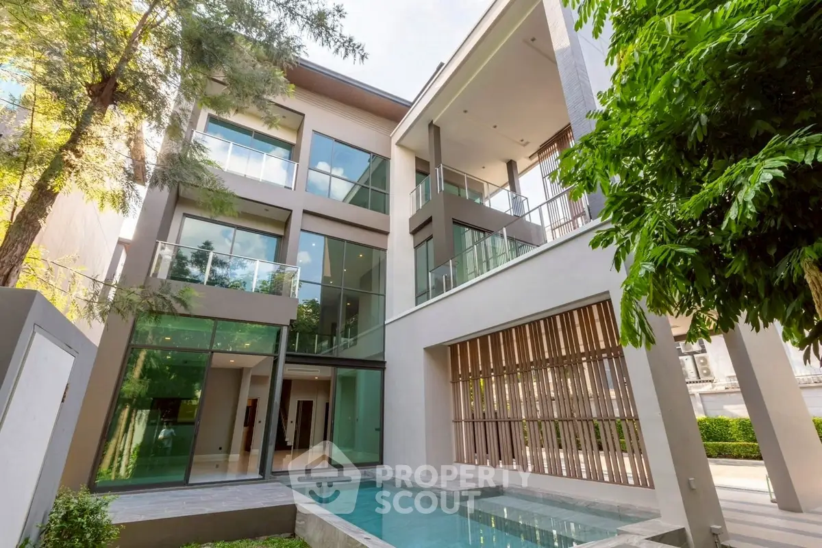 Luxurious modern building with pool and lush greenery, perfect for upscale living.