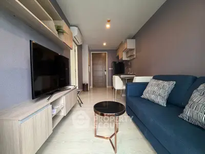 Modern living room with sleek furniture and open kitchen layout, perfect for urban living.