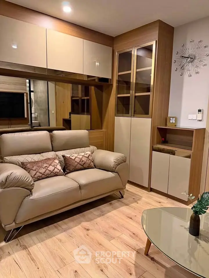Modern living room with stylish furniture and wooden flooring, featuring a cozy sofa and elegant decor.