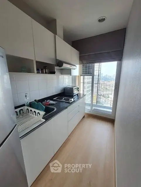 Modern kitchen with city view, sleek cabinets, and natural light, perfect for urban living.