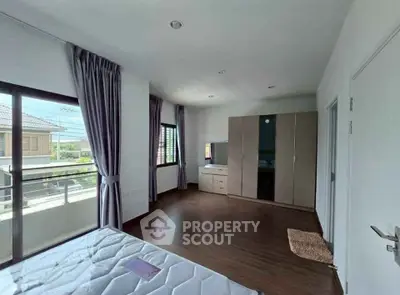 Spacious bedroom with balcony access and modern wardrobe in a bright home.