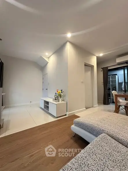 Modern living room with stylish decor and open layout, featuring cozy seating and elegant flooring.