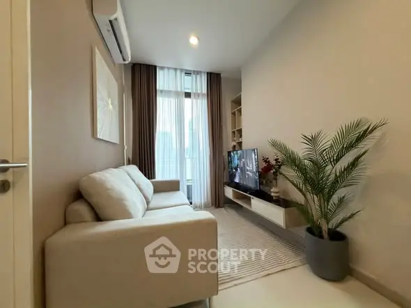 Modern living room with cozy sofa, TV, and large window with city view.