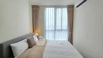 Cozy bedroom with large window and air conditioning in modern apartment