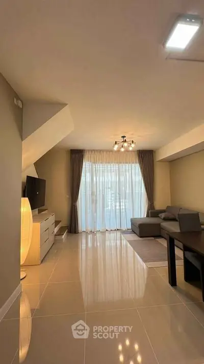 Spacious living room with modern decor and large windows for natural light.