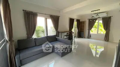 Spacious modern living room with large windows and elegant curtains