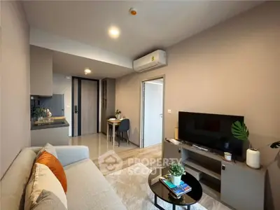 Modern living room with cozy sofa, TV, and dining area in stylish apartment.