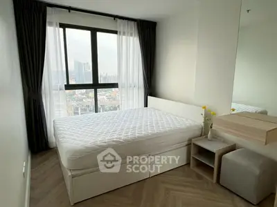 Modern bedroom with city view, featuring a comfortable bed and stylish decor.
