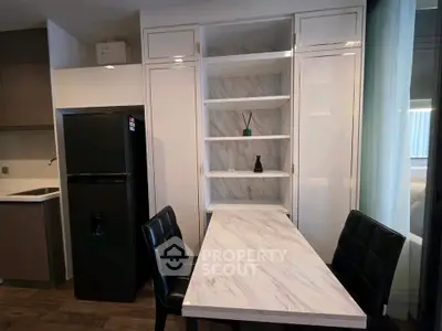 Modern kitchen with sleek black fridge and marble dining table