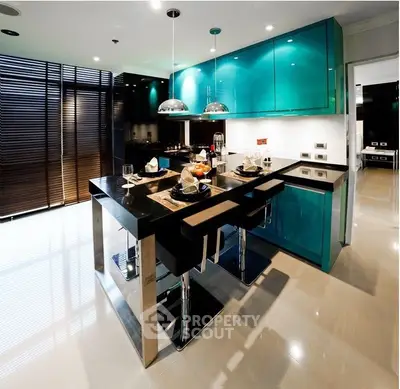Sleek modern kitchen with vibrant turquoise cabinets, stainless steel appliances, and a large island with seating, perfect for entertaining.