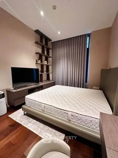 Modern bedroom with sleek furniture and large window, featuring a comfortable mattress and stylish shelving.