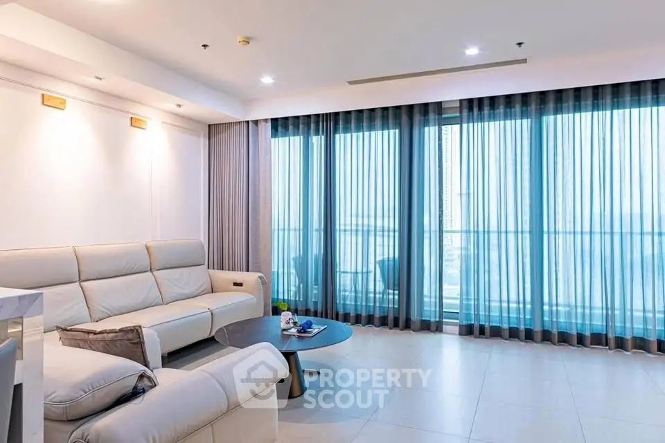 Spacious modern living room with large windows and elegant furnishings