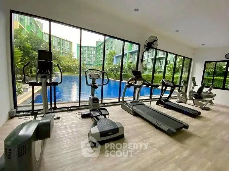 Modern gym with pool view in luxury residential complex