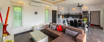 Modern open-plan living room and kitchen with stylish decor and natural light.