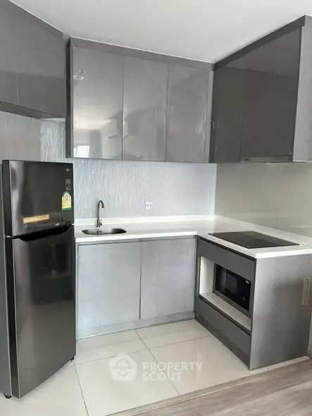 Modern kitchen with sleek grey cabinets and stainless steel appliances.