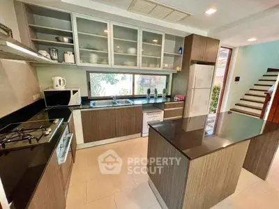 Modern kitchen with island, gas stove, and sleek cabinetry in a stylish home.