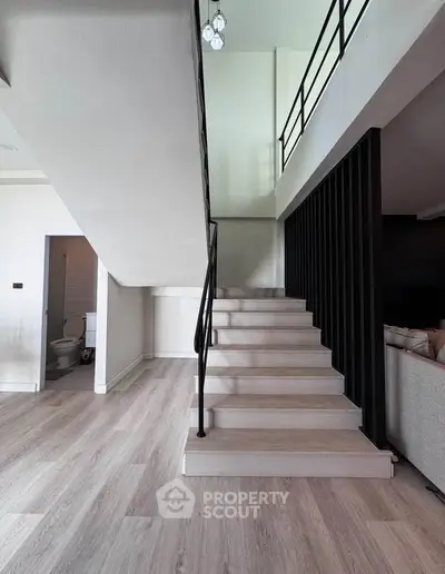 Modern duplex interior with sleek staircase and open living space