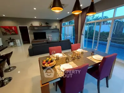 Luxurious open-plan living room with pool view, elegant dining area, and modern decor.
