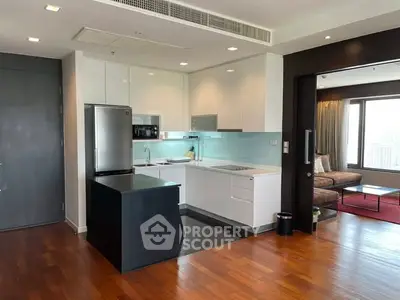 Modern open-layout kitchen with sleek appliances and adjacent cozy living area.